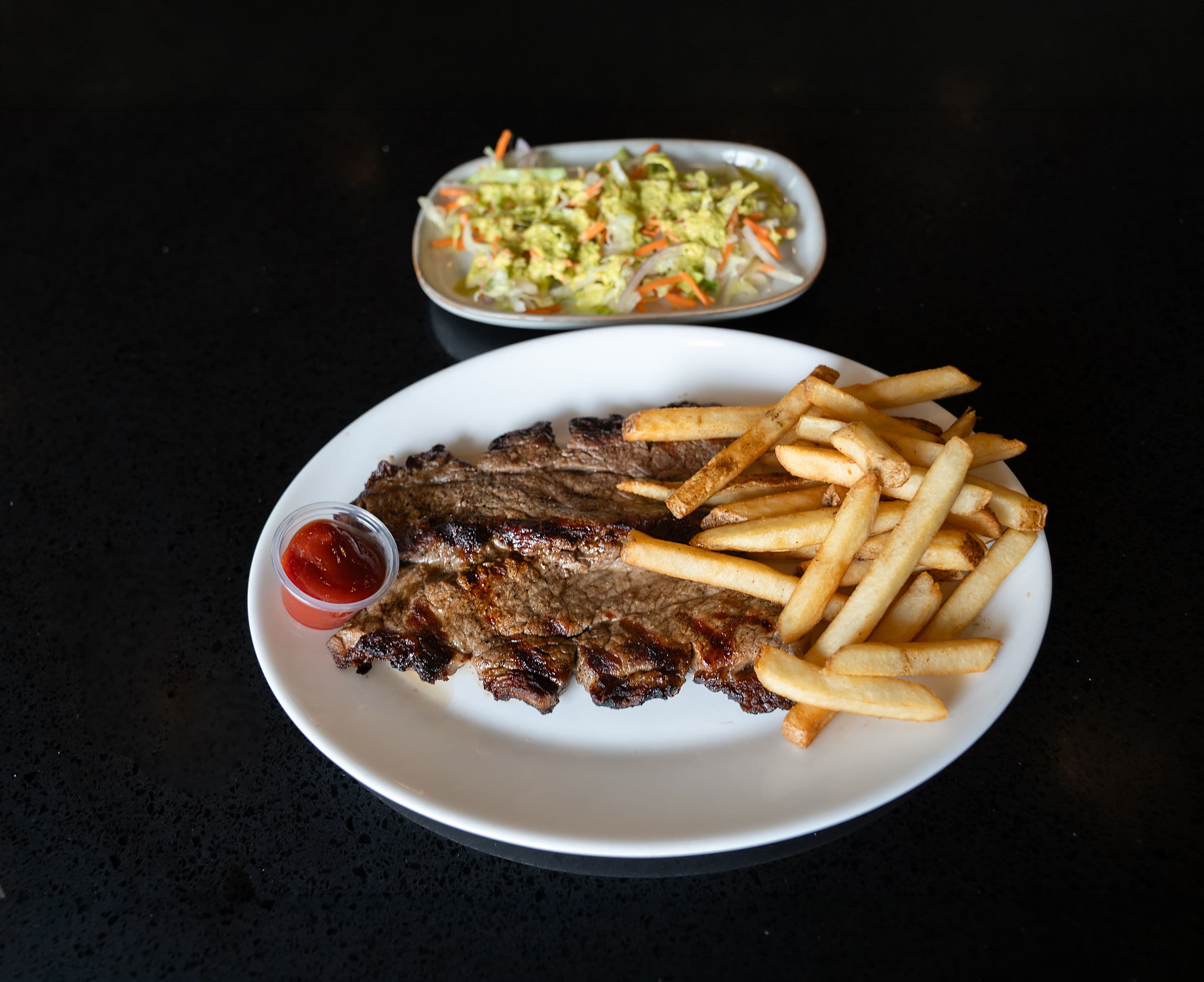 Argentinian Churrasco Grilled Argentinian-style steak served with fries and salad.