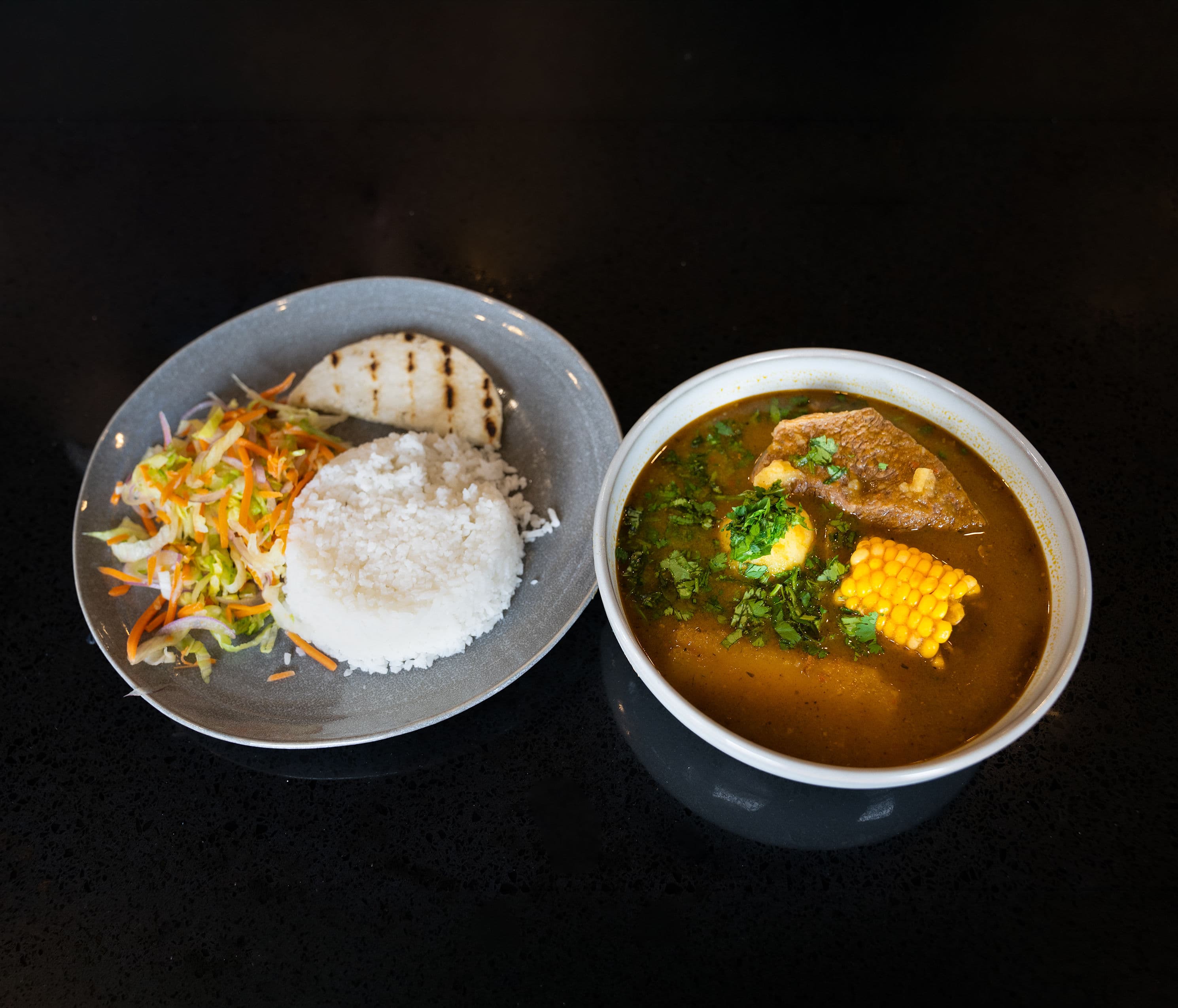 Sancocho Traditional Colombian soup made with chicken, yucca, plantain, and corn.